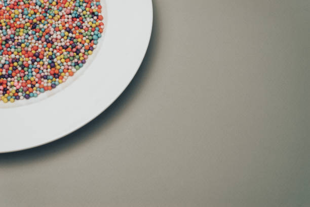 istock White plate with color preparations (vitamins, dyes, flavor enhancers, nutritional supplements, innovative technologies, candy sweets) on a gray background. 1146725766