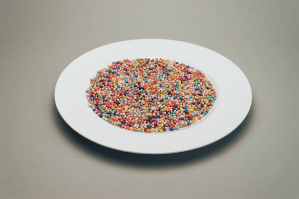 istock White plate with color preparations (vitamins, dyes, flavor enhancers, nutritional supplements, innovative technologies, candy sweets) on a gray background. 1146725867