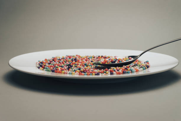istock White plate with color preparations (vitamins, dyes, flavor enhancers, nutritional supplements, innovative technologies, candy sweets) on a gray background. 1146725895