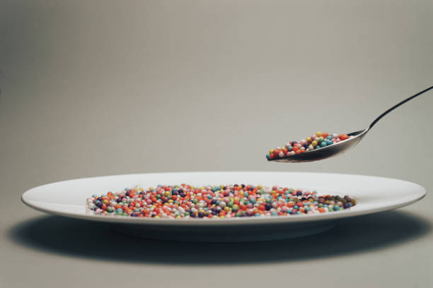 istock White plate with color preparations (vitamins, dyes, flavor enhancers, nutritional supplements, innovative technologies, candy sweets) on a gray background. 1146727051