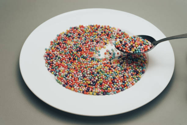 istock White plate with color preparations (vitamins, dyes, flavor enhancers, nutritional supplements, innovative technologies, candy sweets) on a gray background. 1146727093