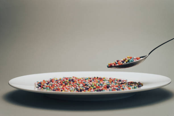 istock White plate with color preparations (vitamins, dyes, flavor enhancers, nutritional supplements, innovative technologies, candy sweets) on a gray background. 1146727288