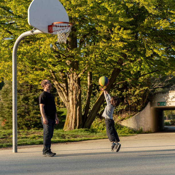 vater und sein 7-jähriger sohn spielen basketball im stanley park, vancouver, kanada - 6 7 years stock-fotos und bilder