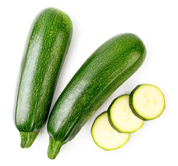 Ripe zucchini and sliced slices on a white background. The form of the top.