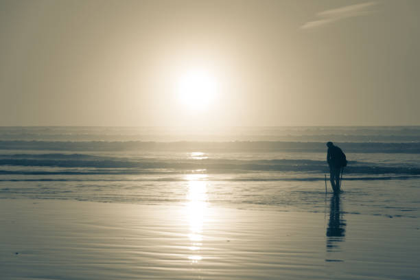 A photographer in Reynisfjara Black Sand Beach, Vik, Iceland, North Atlantic Ocean