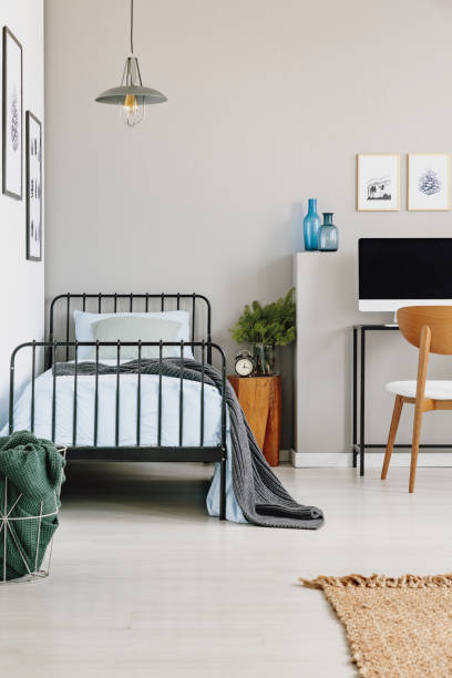 istock Single industrial bed with blue bedding in stylish grey bedroom, copy space on empty wall 1146732144