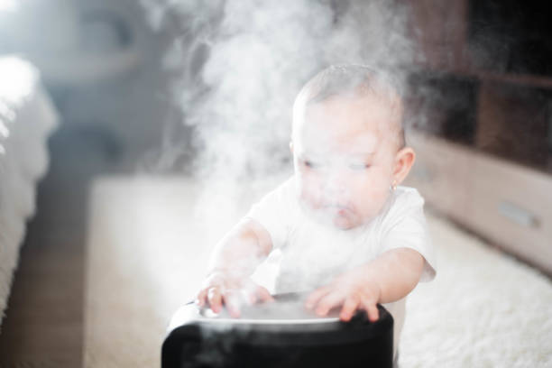 il bambino guarda l'umidificatore. umidità nel concetto di aria sana domestica - contemporary domestic room sparse indoors foto e immagini stock