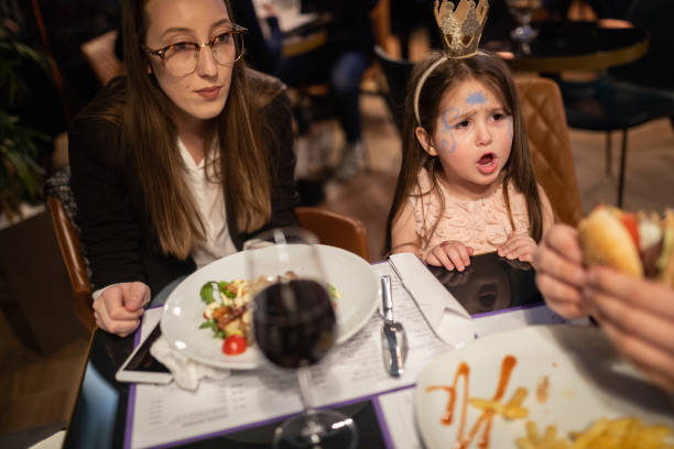 Cute girl complaining while at a birthday dinner with parents