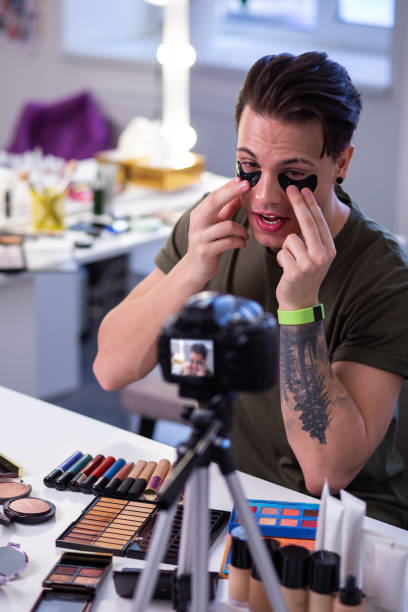 istock Curious extraordinary man sitting at the table surrounded with makeup 1146734052