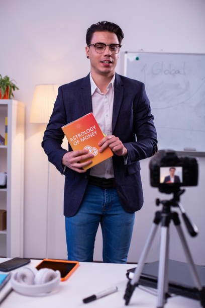 istock Smart man in black jacket carrying book about money and finances 1146735578