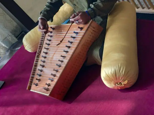 Stock photo of man playing santoor instrument in India. Made of wood with up to 100 strings, santoors provide traditional background music in restaurants.