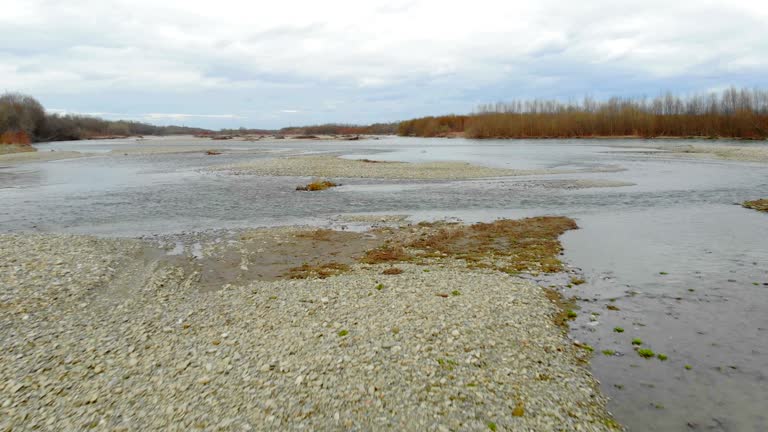 Low flying drone over the river with rocks.