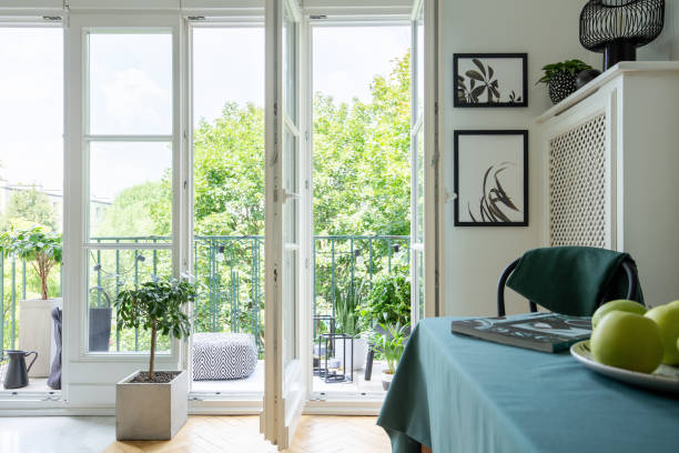 istock Bright room interior with two posters, magazine on table and balcony with pouf, fresh plants and lights in real photo 1146741176