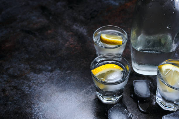 istock Vodka. Shots, glasses with vodka and lemon with ice .Dark stone background. 1146741227