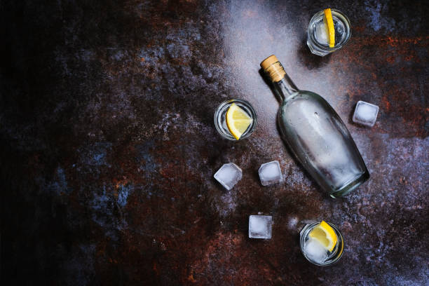 istock Cold vodka in shot glasses with lemon on stone background. Top view, copy space. 1146741239
