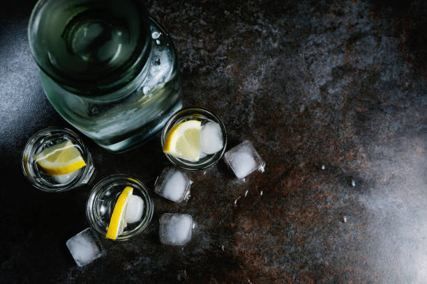 istock Vodka in glasses with lemon and ice. On the black stone table. Copyspace. 1146741245