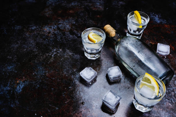 istock Cold vodka in shot glasses with lemon on stone background. Top view, copy space. 1146741252
