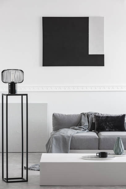 istock Grey blanket and black pillow on comfortable sofa in stylish living room interior 1146746065