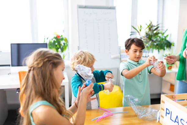 istock Boys and classmate holding plastic bottles for future recycling 1146746541