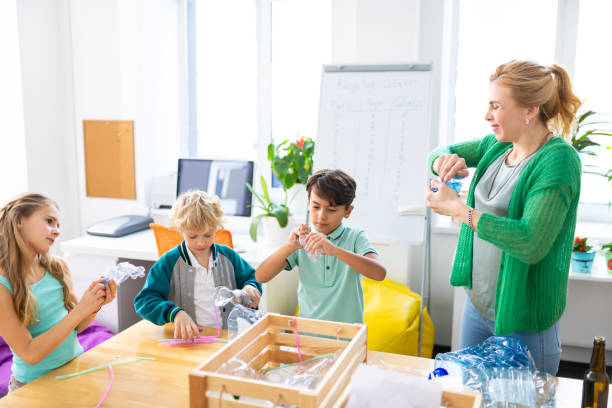 istock Teacher and children preparing plastic bottles for future recycling 1146746548