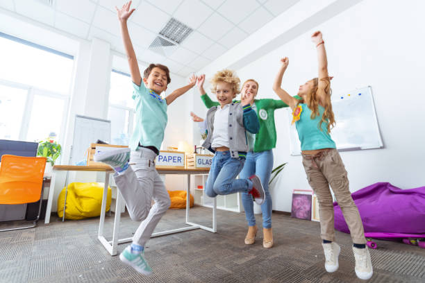 istock Schoolchildren and teacher jumping after sorting litter 1146746587