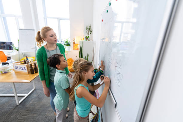 istock Pupils painting different types of waste on whiteboard 1146747389