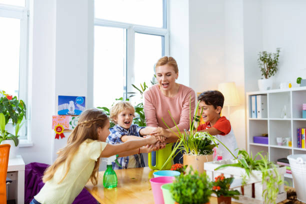istock Teacher and pupils holding hands together while feeling friendly 1146747488
