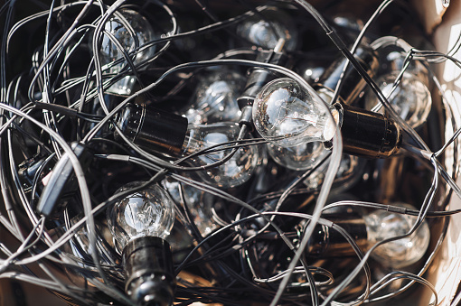 A hank of electric glass bulbs with a wire as a background for sale. Lighting equipment for home, holiday and nature.
