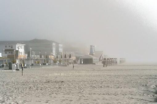 The marine layer has collapsed on the ocean city beach obscuring people and places, The lifeguard chairs have been pulled back from the shoreline and folks will just wait it out to start their vacation