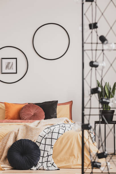 istock Vertical view of classy bedroom interior with colorful bedding and round pillows 1146752250