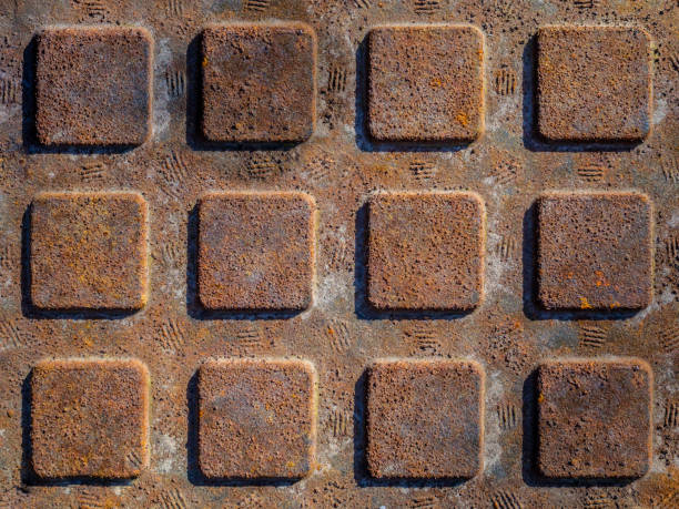 Old rusty manhole cover, grooved, dirty, corrosion, red