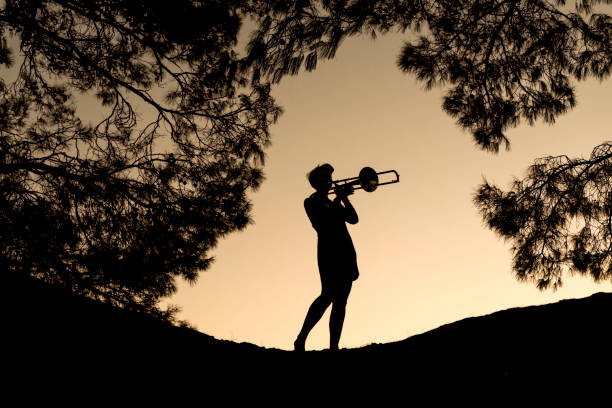 istock Young woman playing trombone 1146755439