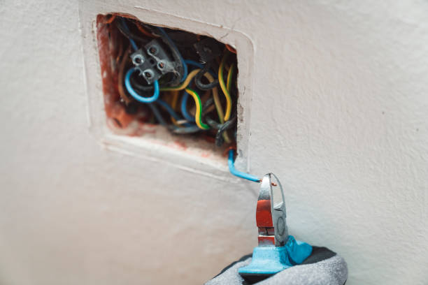 istock Using clamps to clamp colorful wires in a hole in a wall 1146755616