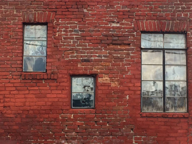 istock Very old brick wall in need of pointing repair with three different windows, architectural background 1146761804