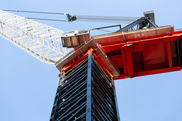 Closeup Tower crane top part with cabin, low angle view, blue sky background with copy space Closeup tower crane top part with cabin, low angle view, blue sky background with copy space, full frame horizontal composition wire rope stock pictures, royalty-free photos & images