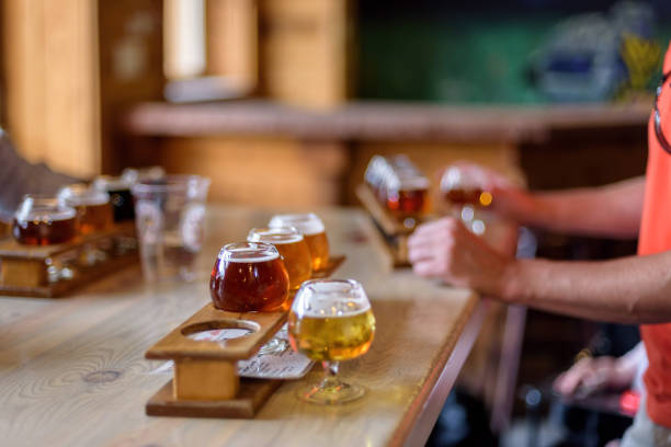 Man sampling beer at local microbrewery Variety of beer samples on the table at local microbrewery tasting room microbrewery stock pictures, royalty-free photos & images