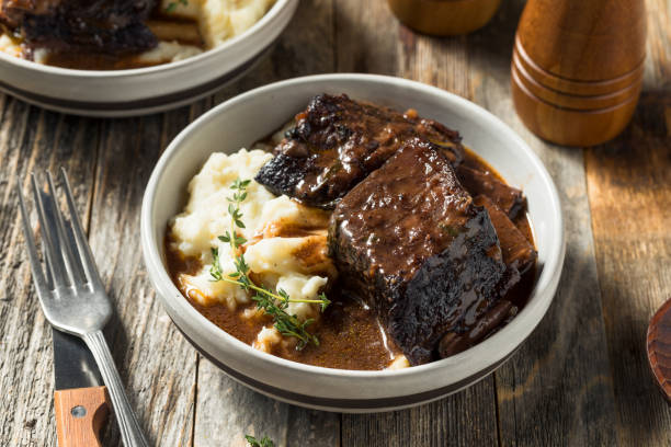 Homemade Braised Beef Short Ribs Homemade Braised Beef Short Ribs with Gravy and Potatoes braised stock pictures, royalty-free photos & images