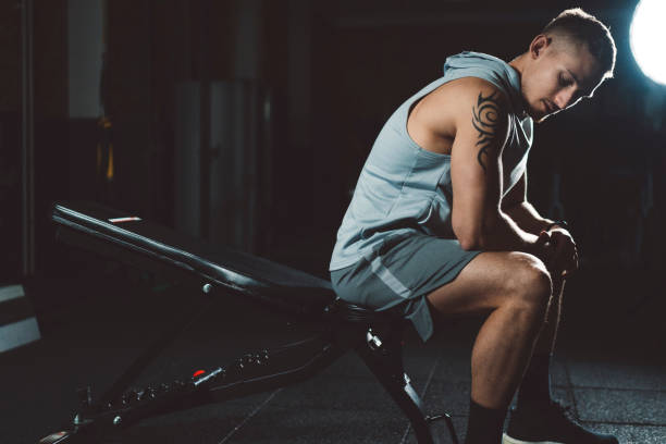 istock A young male model with tattoos sitting on a bench in gym 1146774735