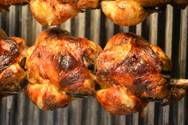 poulet rôti juteux sur une broche - rotisserie chicken barbecue grill food photos et images de collection