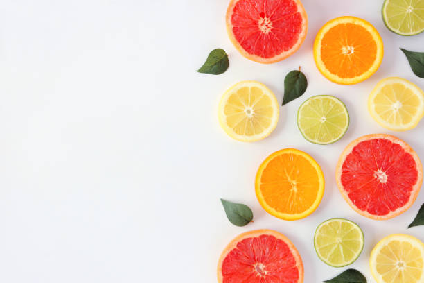 beira lateral da fruta colorida de fatias e de folhas do citrino, vista superior sobre um fundo branco - healthy eating multi colored orange above - fotografias e filmes do acervo