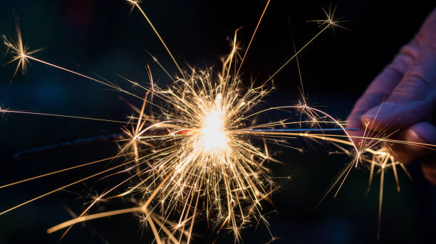 istock Closeup of man’s hand holding lit sparkler 1146780432