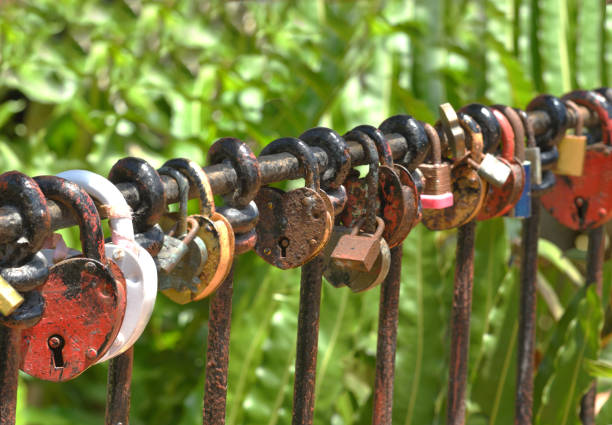 Various Colorful Locks Hanging on a Metal Railing Outside