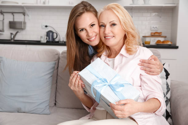 istock Mother and daughter together at home weekend holding gift box 1146790681