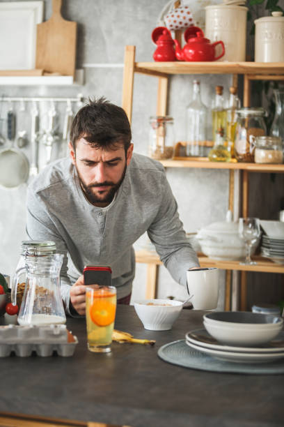 istock Man frowning while looking at smart phone during breakfast at home 1146790727
