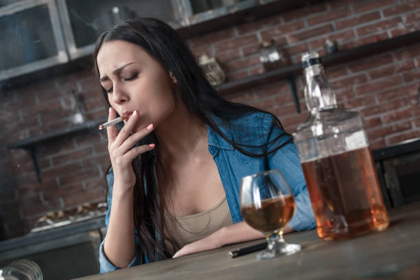 istock Young woman alcoholic smoker social problems concept sitting puffing cigarette 1146791002
