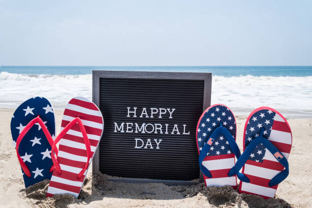 Happy Memorial day background on the beach Happy Memorial day background with black board and flip flops with american flag colors on the sandy beach near the ocean usa flag shoes stock pictures, royalty-free photos & images