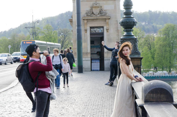 Beautiful asian woman posing for her boyfriend on Charles bridge during day of springtime