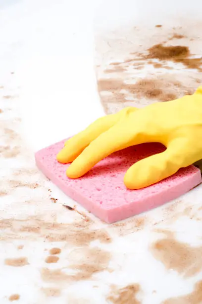 Hand cleaning a counter top or floor covered in spills using a sponge