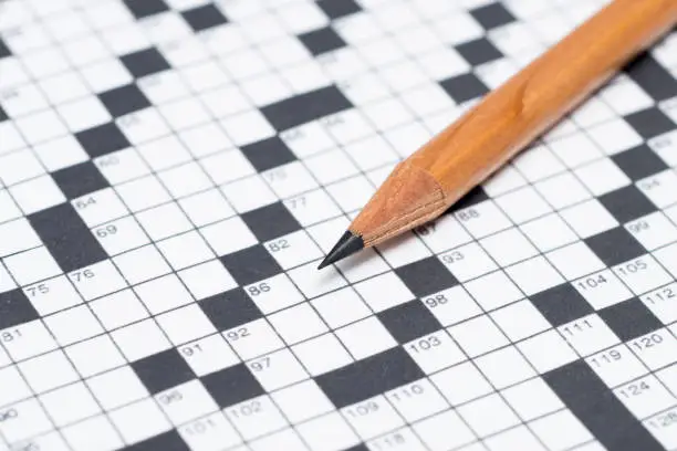 Close up of a pencil on an unanswered crossword puzzle