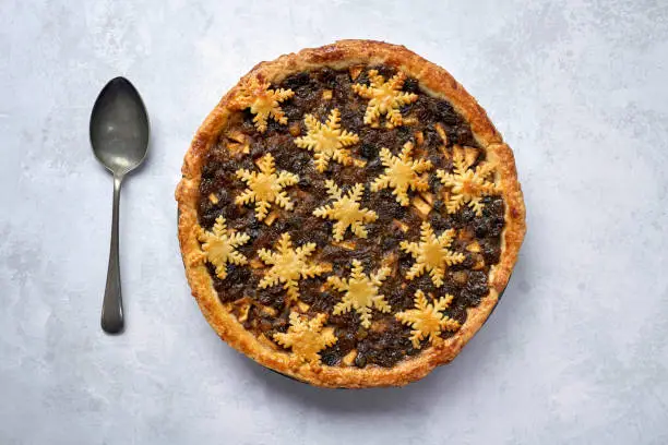 Overhead view of a large whole mince pie and a spoon